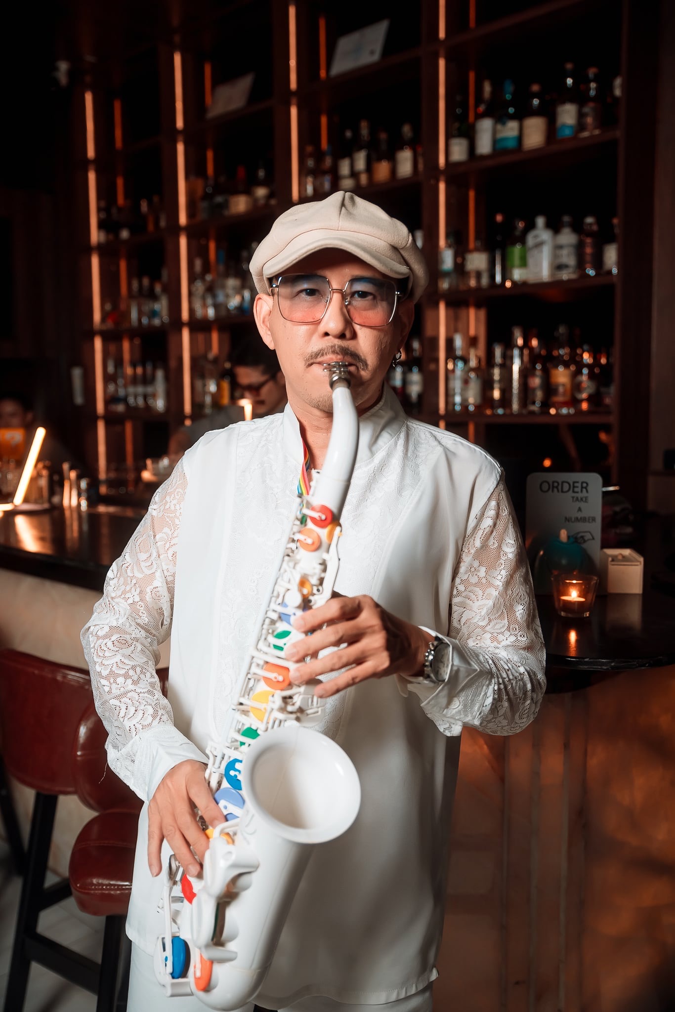 Sir i Sax performing with a white saxophone in a luxury bar setting